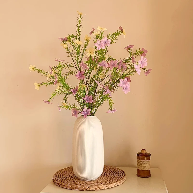 Lebensechte Blumenarrangement mit eleganter Vase