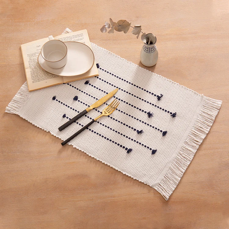 Woven placemats and table runners made of cotton blend with fine dot stripes and knot applications Stornfield
