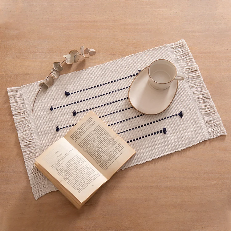 Woven placemats and table runners made of cotton blend with fine dot stripes and knot applications Stornfield