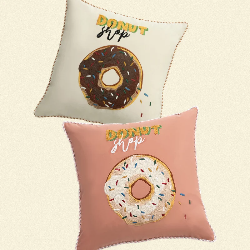 Square decorative pillow cover with hand-embroidered donut appliqué and piping Stornfield
