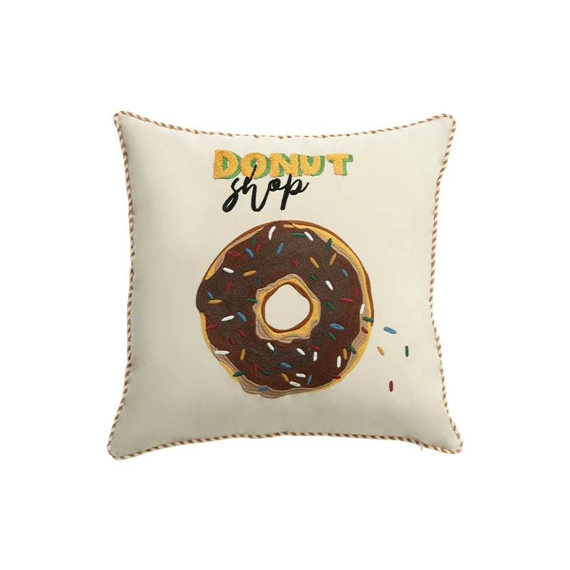 Square decorative pillow cover with hand-embroidered donut appliqué and piping Stornfield