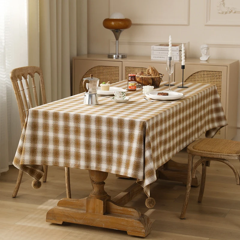 Square tablecloth made of cotton blend fabric with checkered weave pattern and pom-pom corners Stornfield