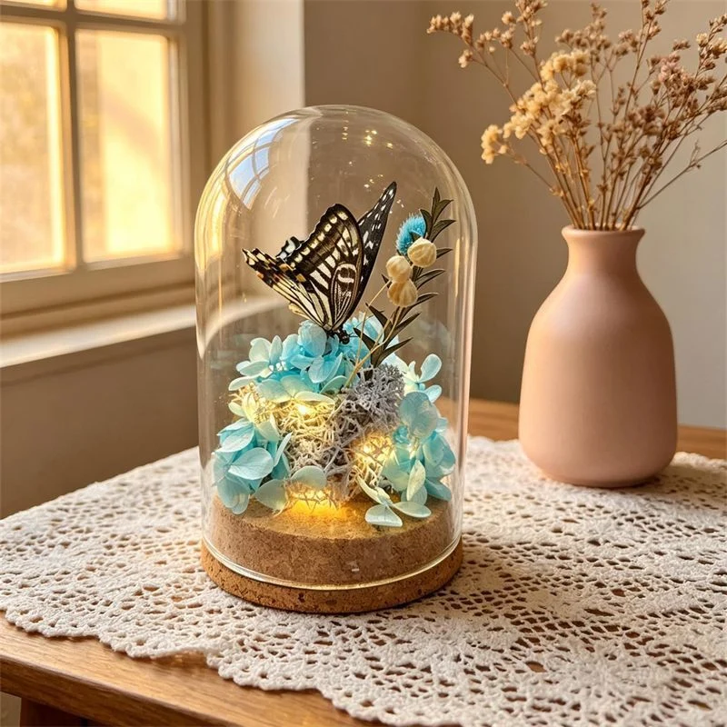 Glas Terrarium mit konservierten Blumen und Schmetterling