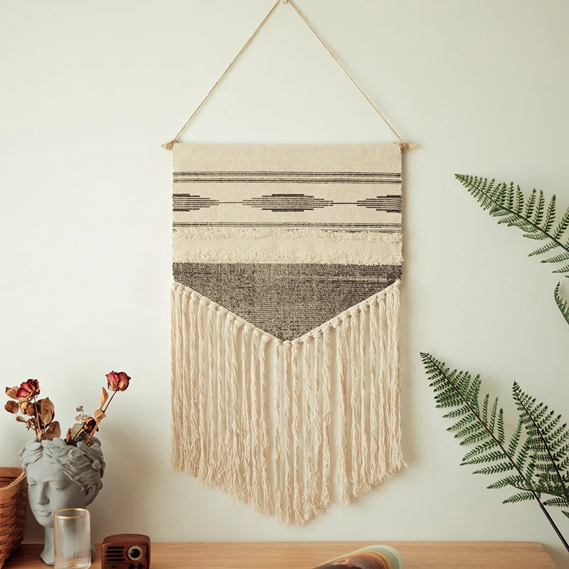Handwoven wall hanging made of cotton blend with layered textures, wood rod and long fringes Stornfield
