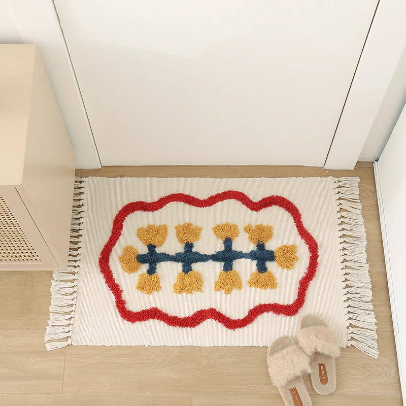 Handwoven cotton bath mat rug with tufted flower appliqué and tassels Stornfield