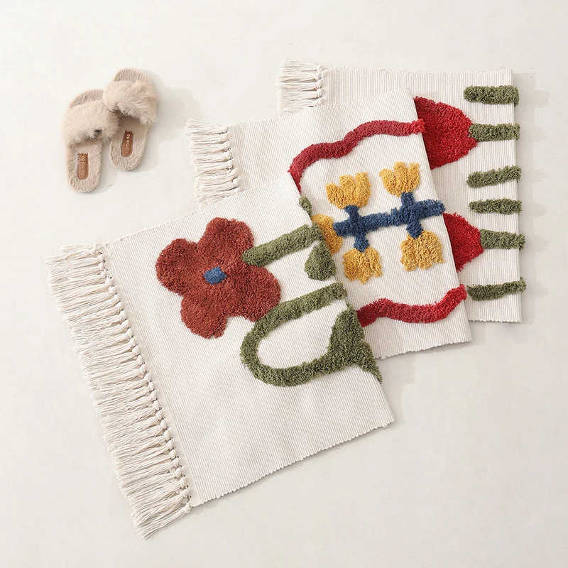 Handwoven cotton bath mat rug with tufted flower appliqué and tassels Stornfield