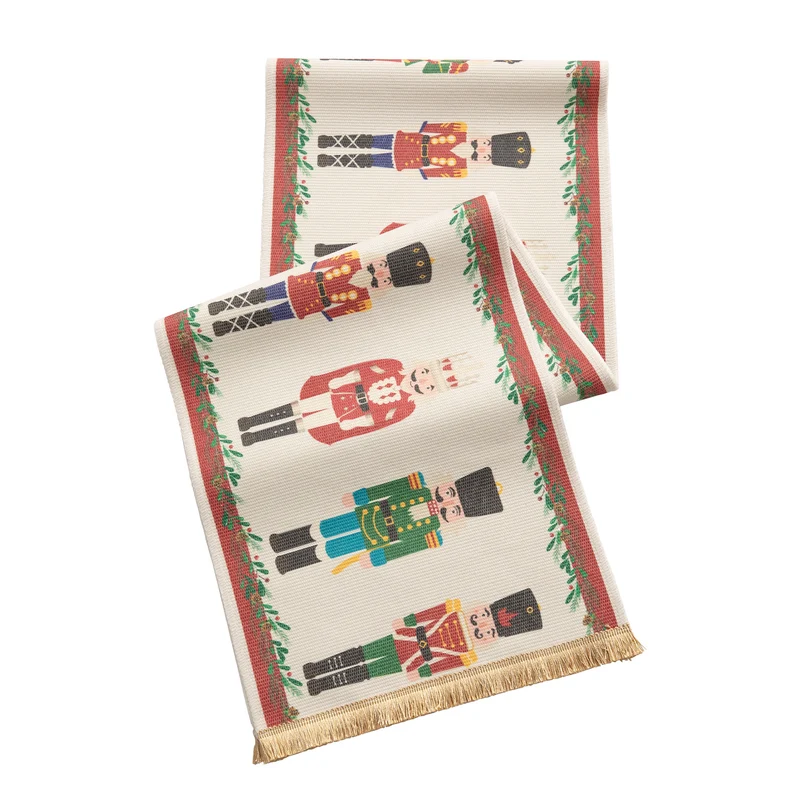 Festive woven table runner with nutcracker motif and golden fringes Stornfield