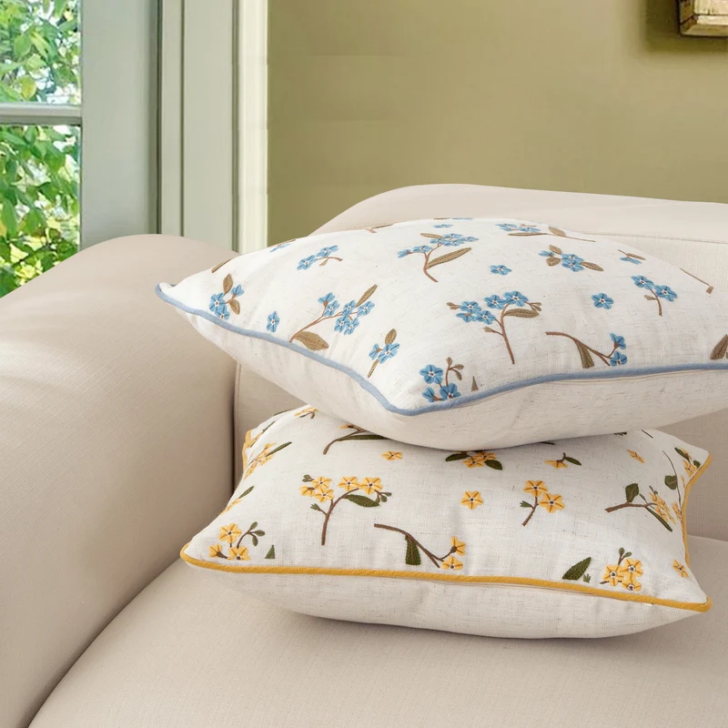 Decorative embroidered cushion cover made of linen blend with floral yellow flower appliqué and piping Stornfield