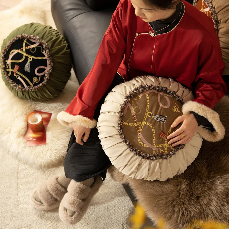 Round decorative pillow with pleated edge, fringe trim, and chain tassel motif Stornfield