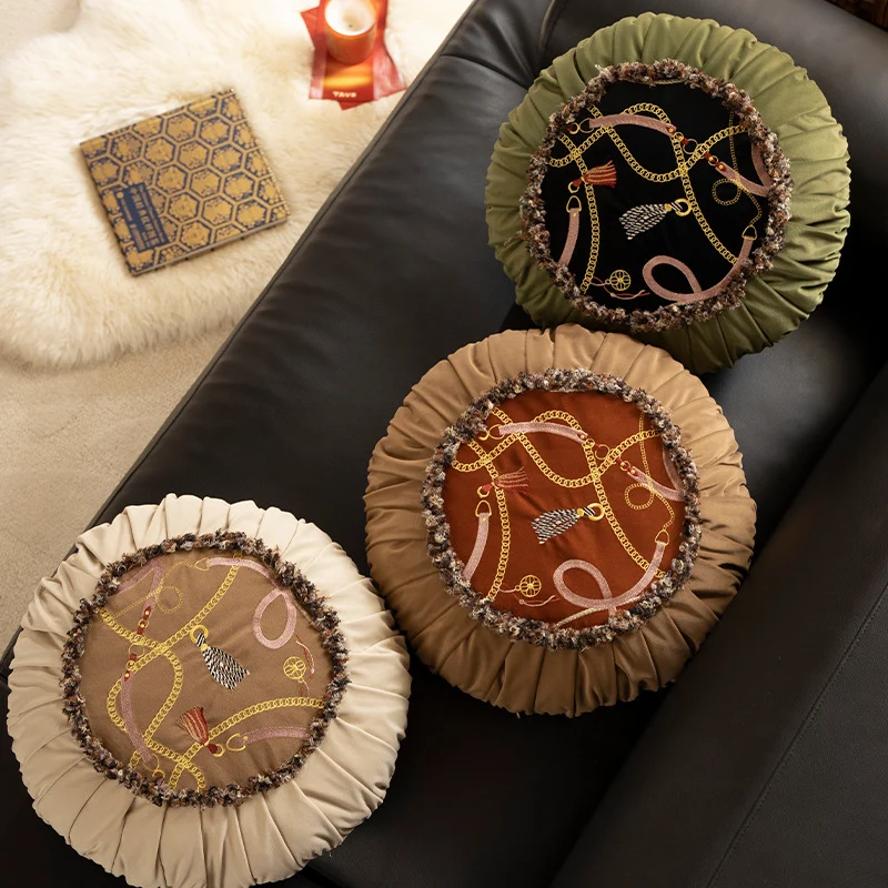 Round decorative pillow with pleated edge, fringe trim, and chain tassel motif Stornfield
