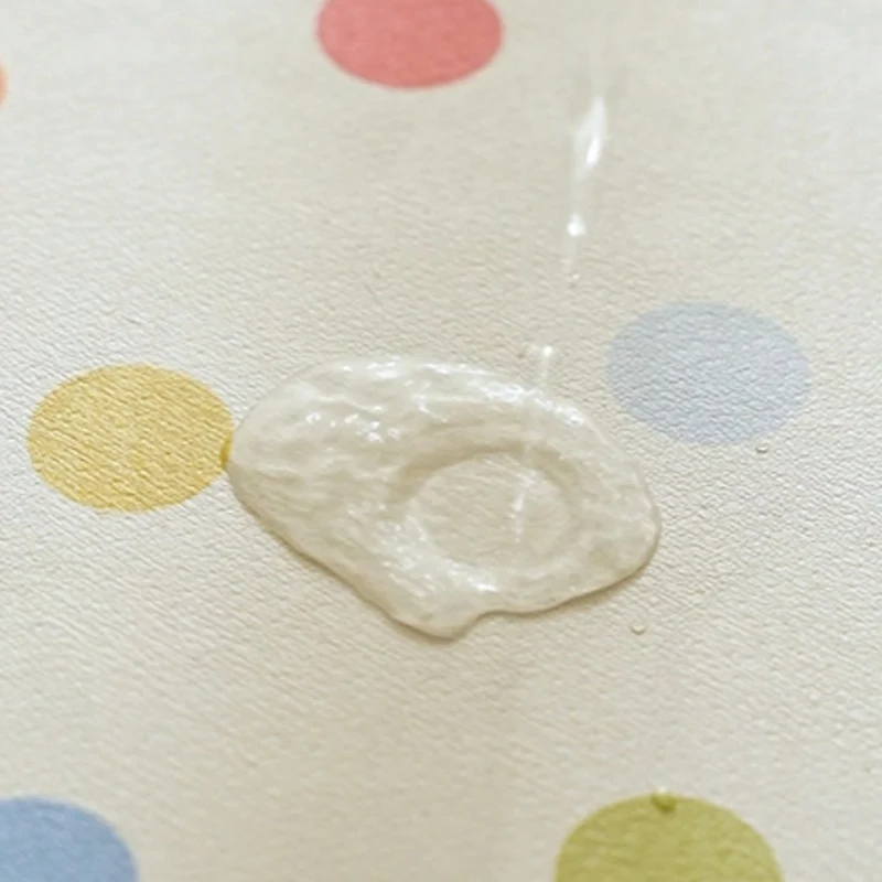 Oval wipeable placemat with pastel-colored polka dots Stornfield