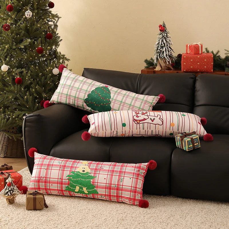 Long decorative lumbar and neck pillow in Christmas check with pompom and dog-tree motif Stornfield