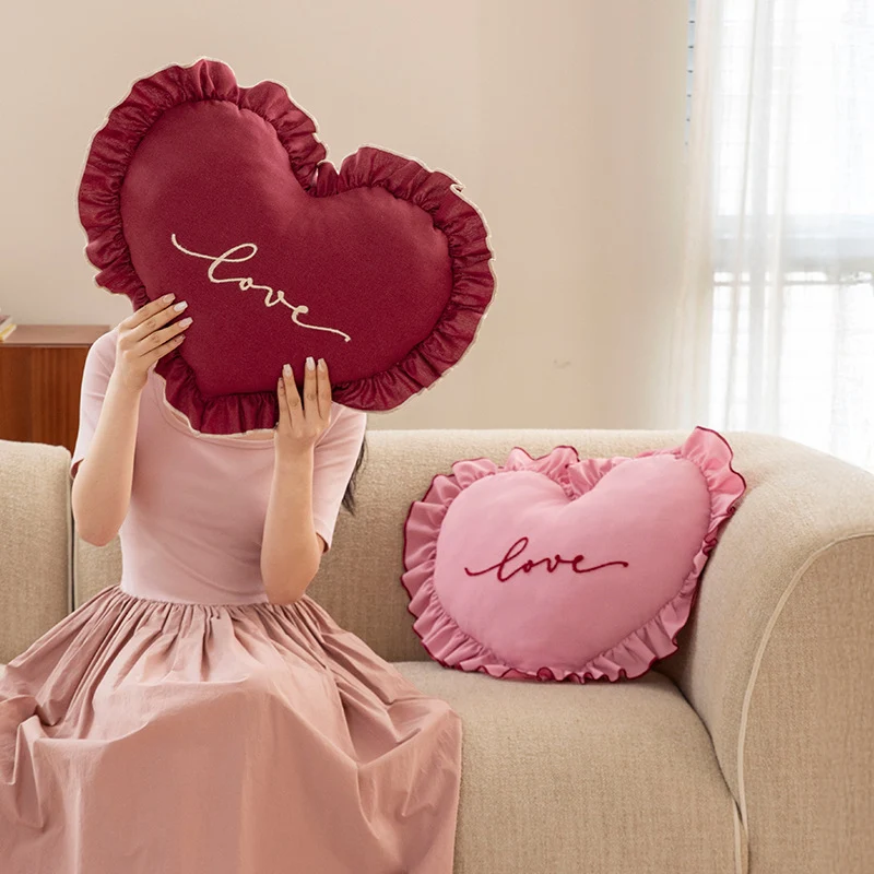 Heart-shaped decorative cushion with ruffles and embroidered text Stornfield