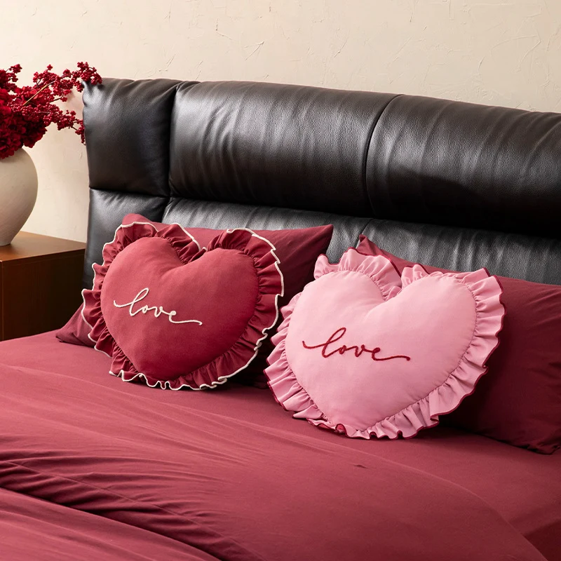 Heart-shaped decorative cushion with ruffles and embroidered text Stornfield