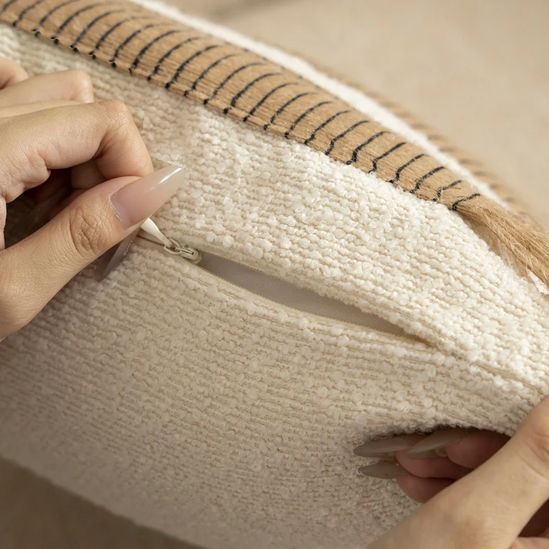 Woven cushion cover with bouclé surface and jute fringes Stornfield