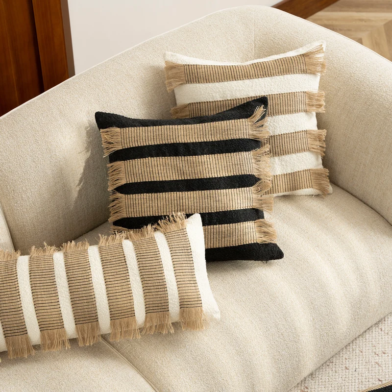 Woven cushion cover with bouclé surface and jute fringes Stornfield