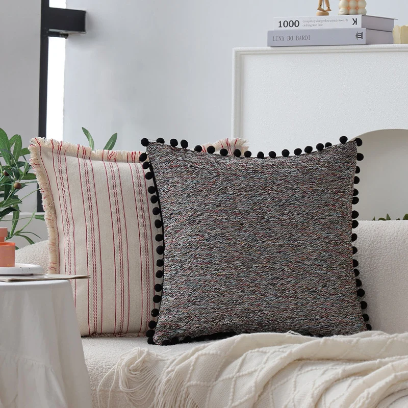 Quadratischer Kissenbezug mit Pompon-Borte und melierter Bouclé‑Struktur Karnz