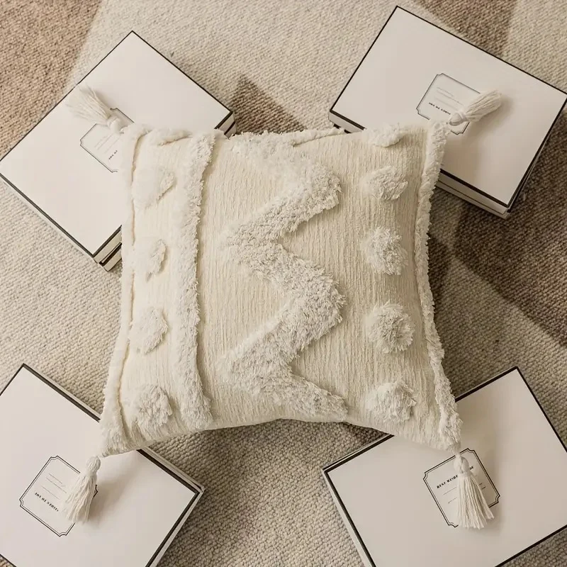 Rectangular decorative cushion cover with hand-tufted chevron and pompom relief as well as corner tassels Stornfield