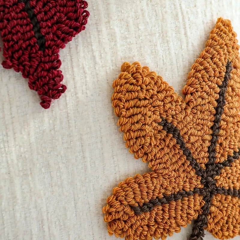 Square cushion cover with hand-tufted autumn leaf appliqués Stornfield