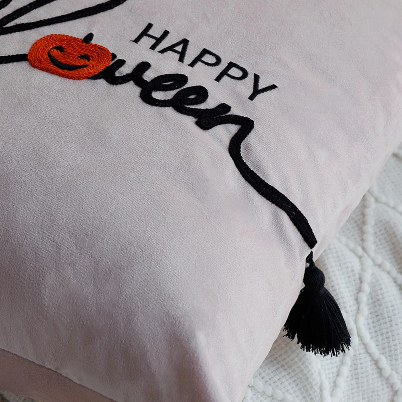 Square decorative cushion cover with embroidered Happy Halloween lettering, pumpkin appliqué, and tassels Stornfield